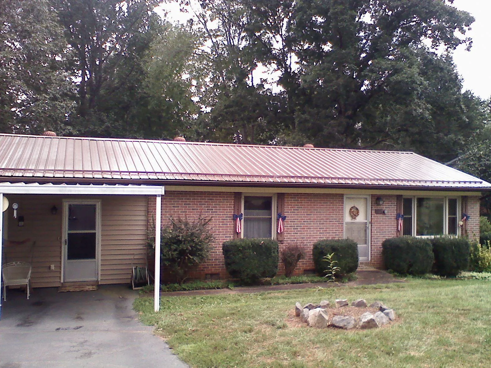 Bronze metal roof and carport on a brick ranch home — Roof Repair work by our crew in Lagrange